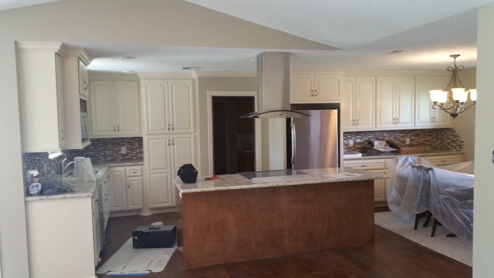 A kitchen with white cabinets and a large island in the middle.