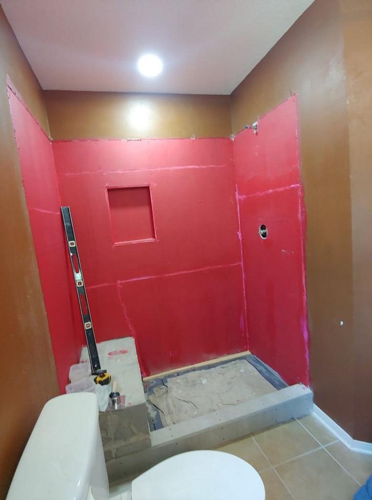 A bathroom with red walls and a toilet