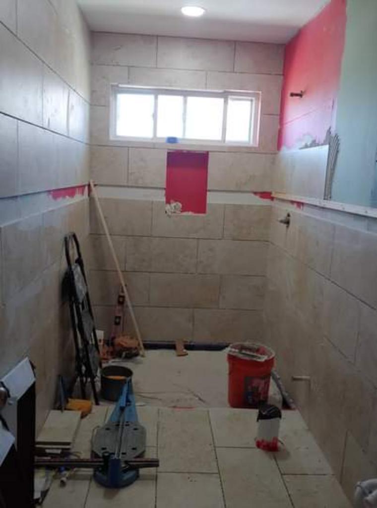 A bathroom is being remodeled with tile and a window.