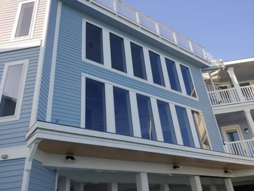 A blue house with a lot of windows and a balcony