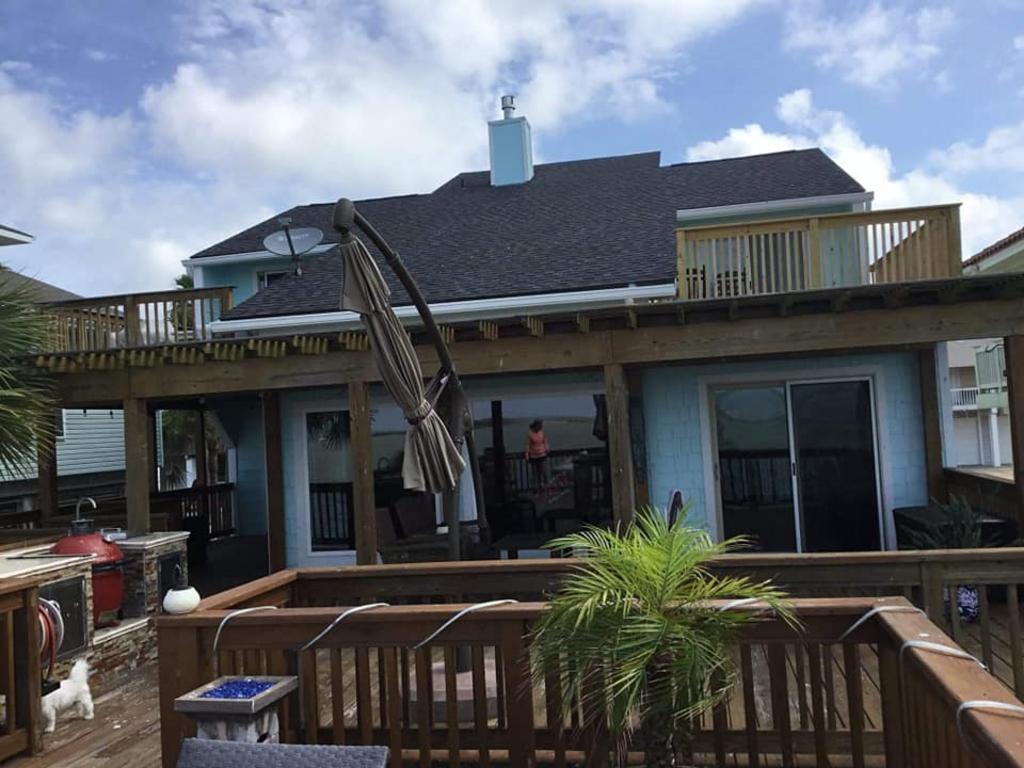 The back of a house with a deck and a roof.