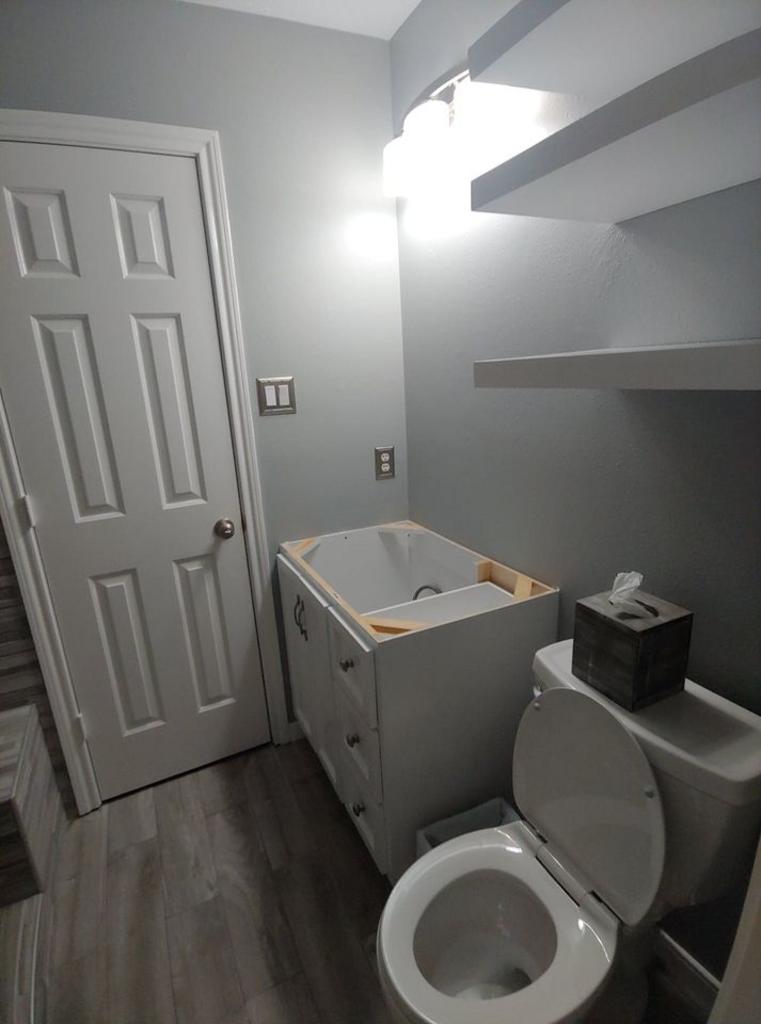 A bathroom with a toilet , sink and bathtub.