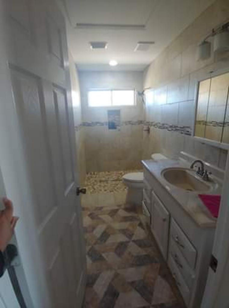 A bathroom with a sink , toilet and shower.