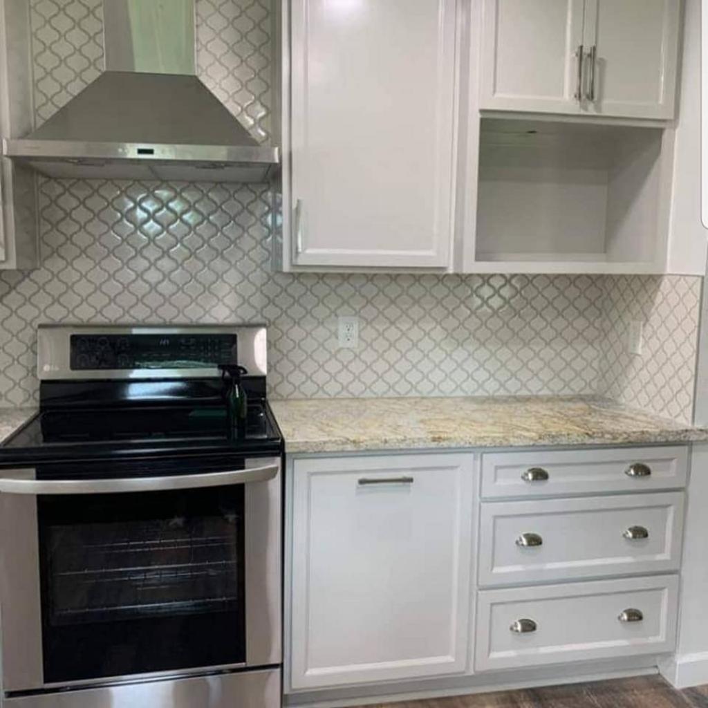 A kitchen with stainless steel appliances and white cabinets.