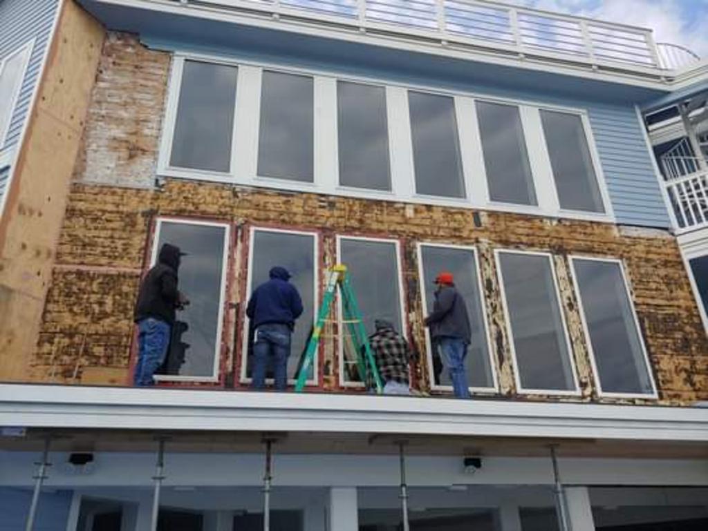 A group of men are working on the side of a building.