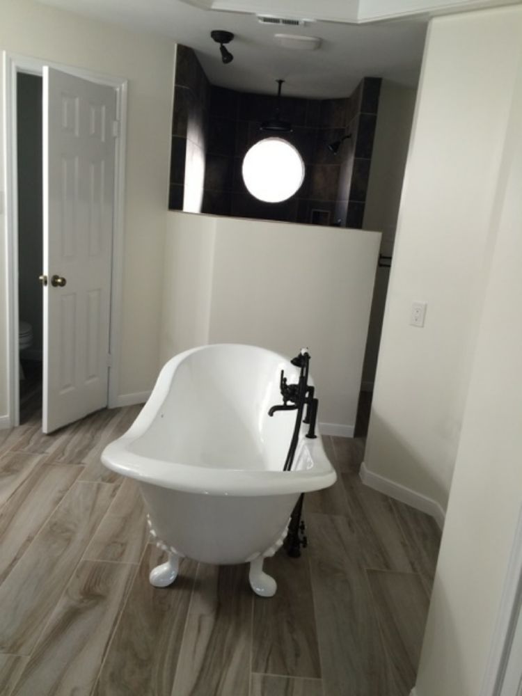 A white bathtub with black faucets in a bathroom