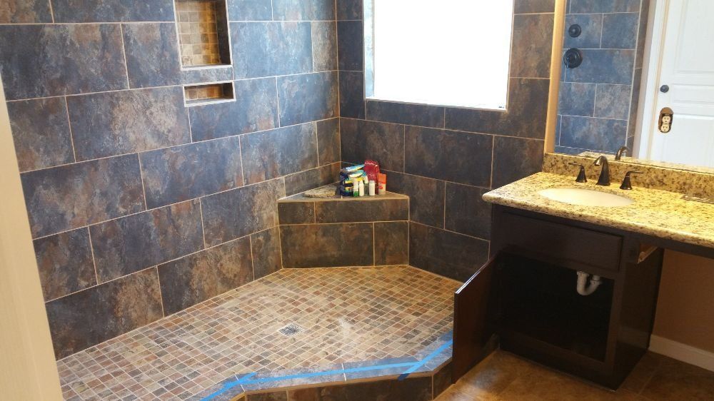 A bathroom with a walk in shower , sink , and mirror.