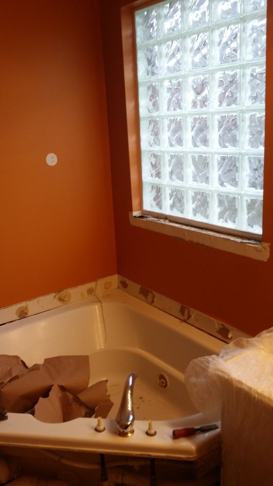 A bathroom with a jacuzzi tub and a window.