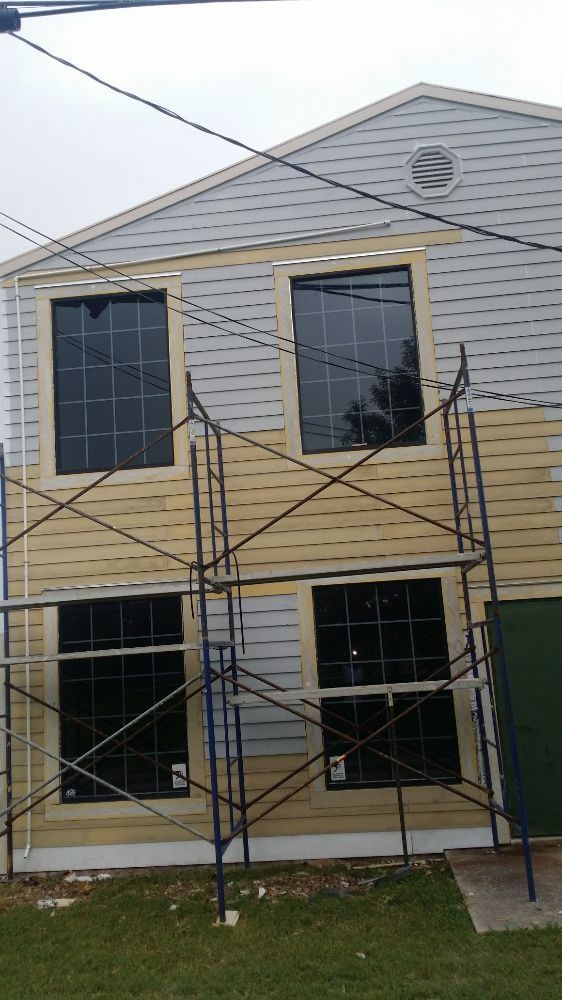 A house is being painted with scaffolding in front of it.