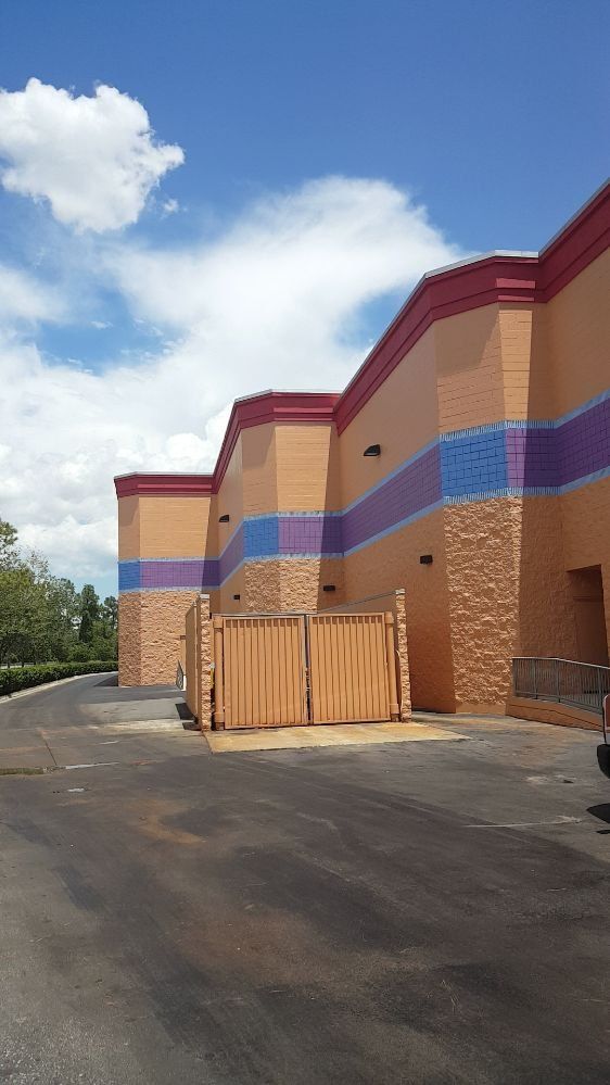 A large building with a lot of windows and a fence in front of it.