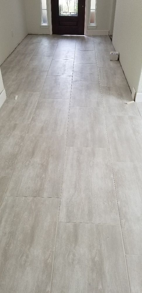 A living room with a tiled floor and a door.