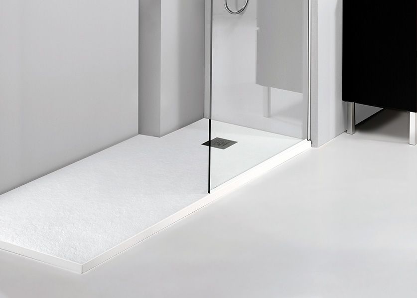 Una cabina de ducha blanca con puerta de cristal en el baño.