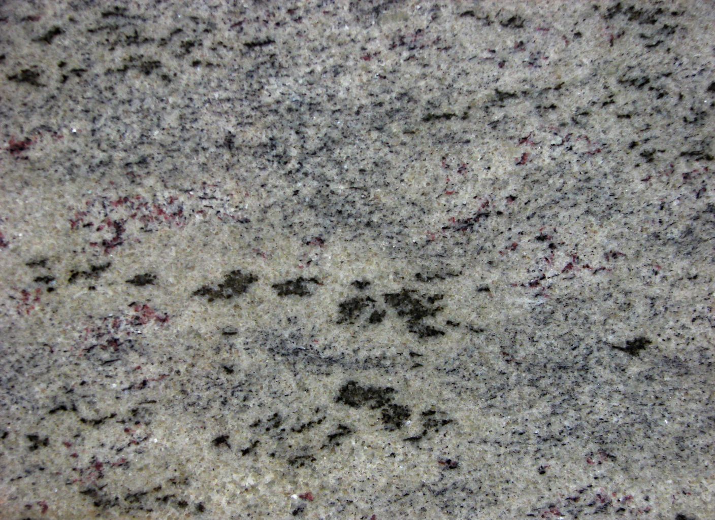Un primer plano de una encimera de granito blanco con manchas negras.