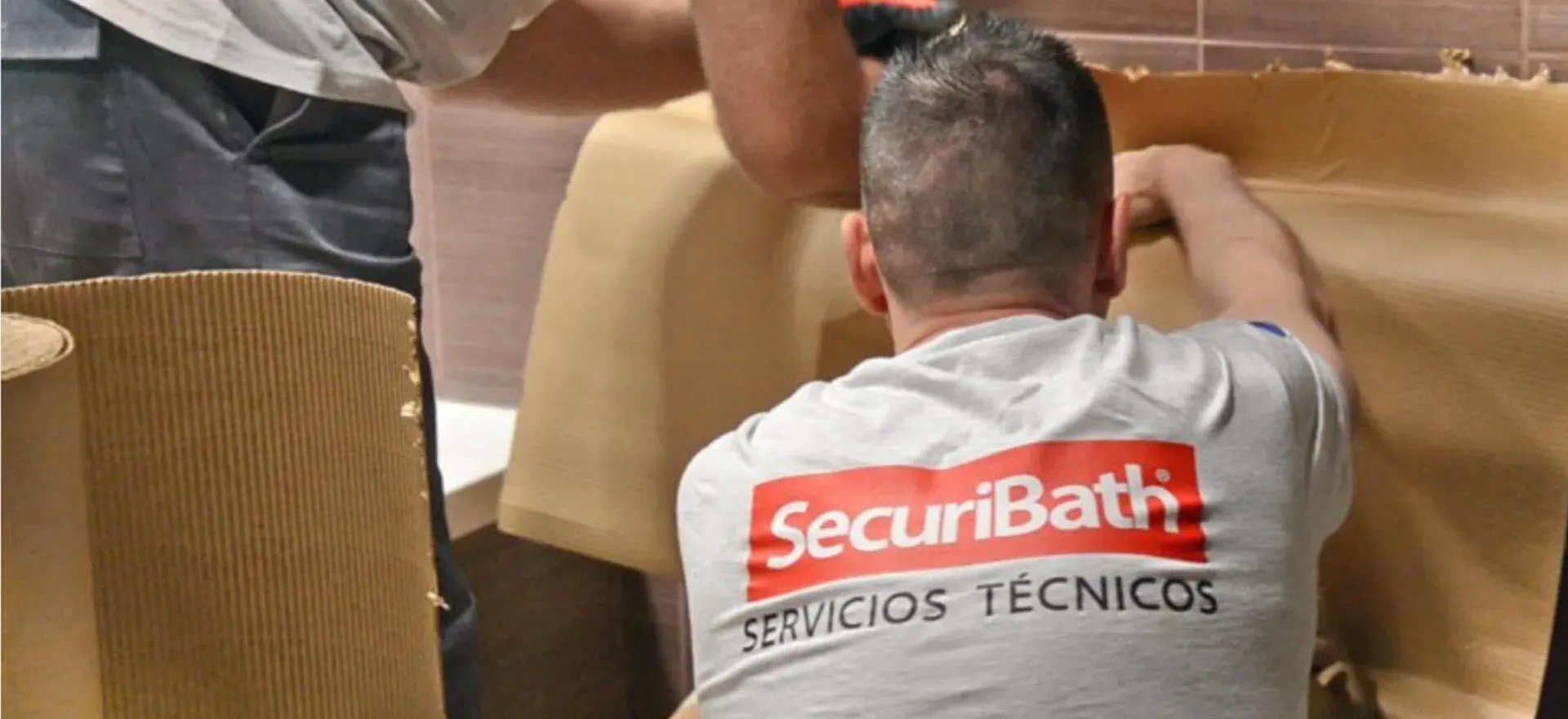 Un hombre que lleva una camiseta de baño de seguridad está trabajando en una bañera.