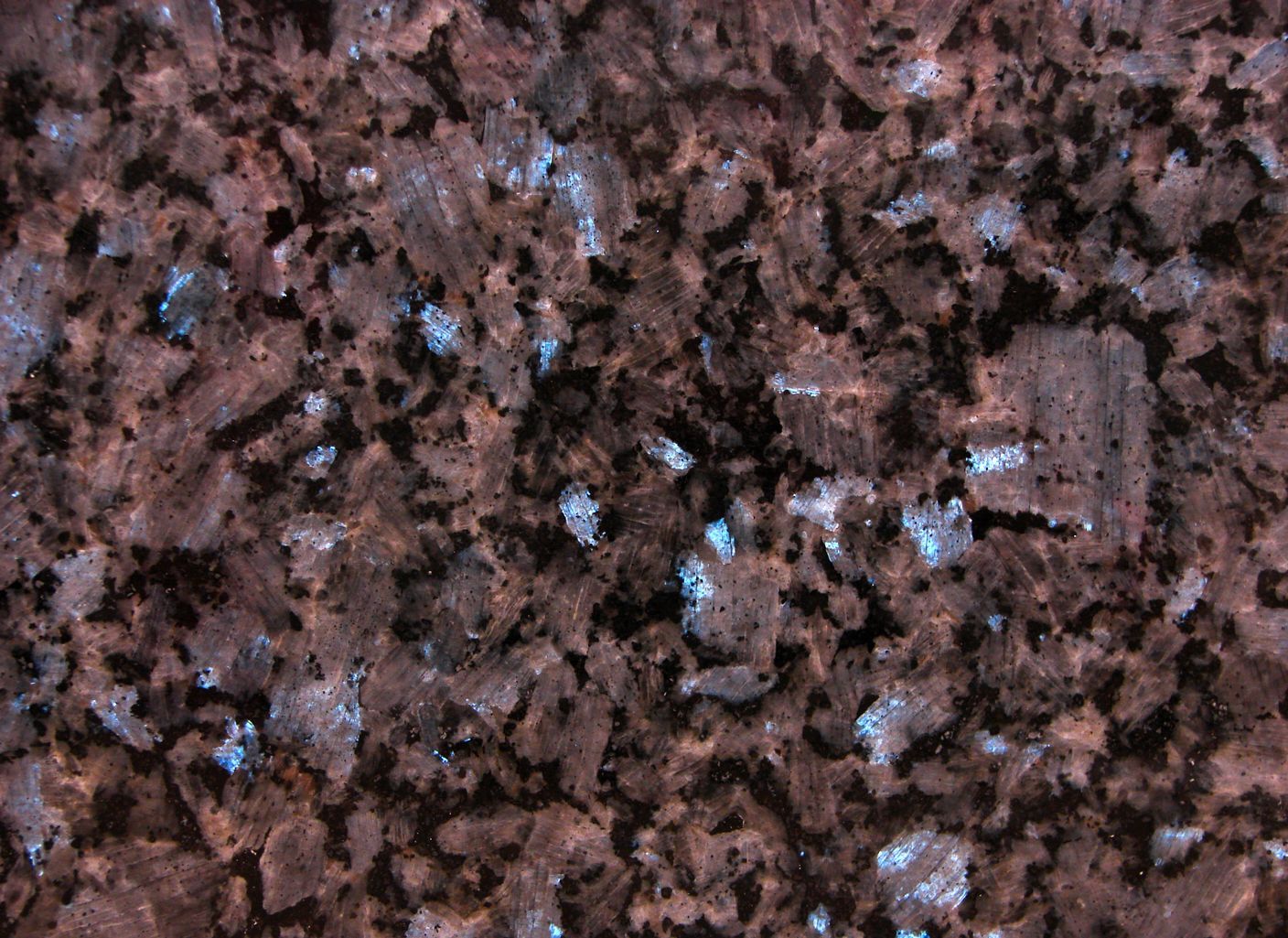 Un primer plano de una encimera de granito marrón con manchas azules.