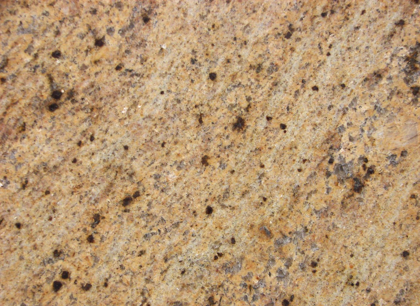 Un primer plano de una encimera de granito amarillo con manchas negras.