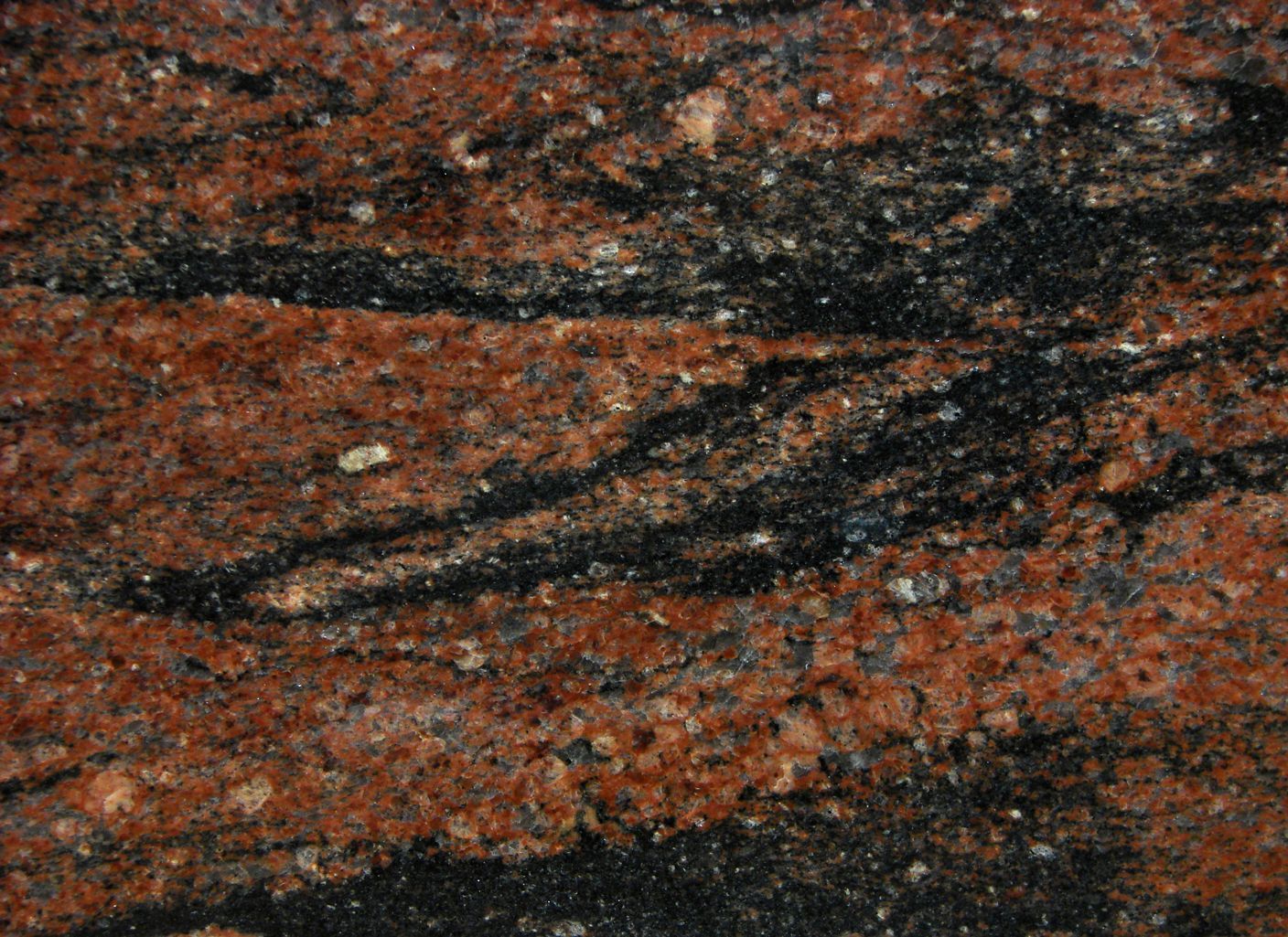 Un primer plano de una superficie de granito rojo y negro.