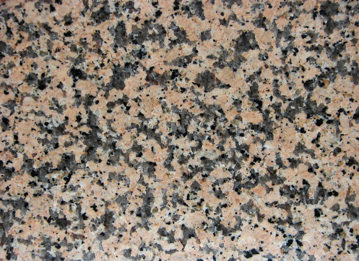 Un primer plano de una encimera de granito con manchas blancas y negras