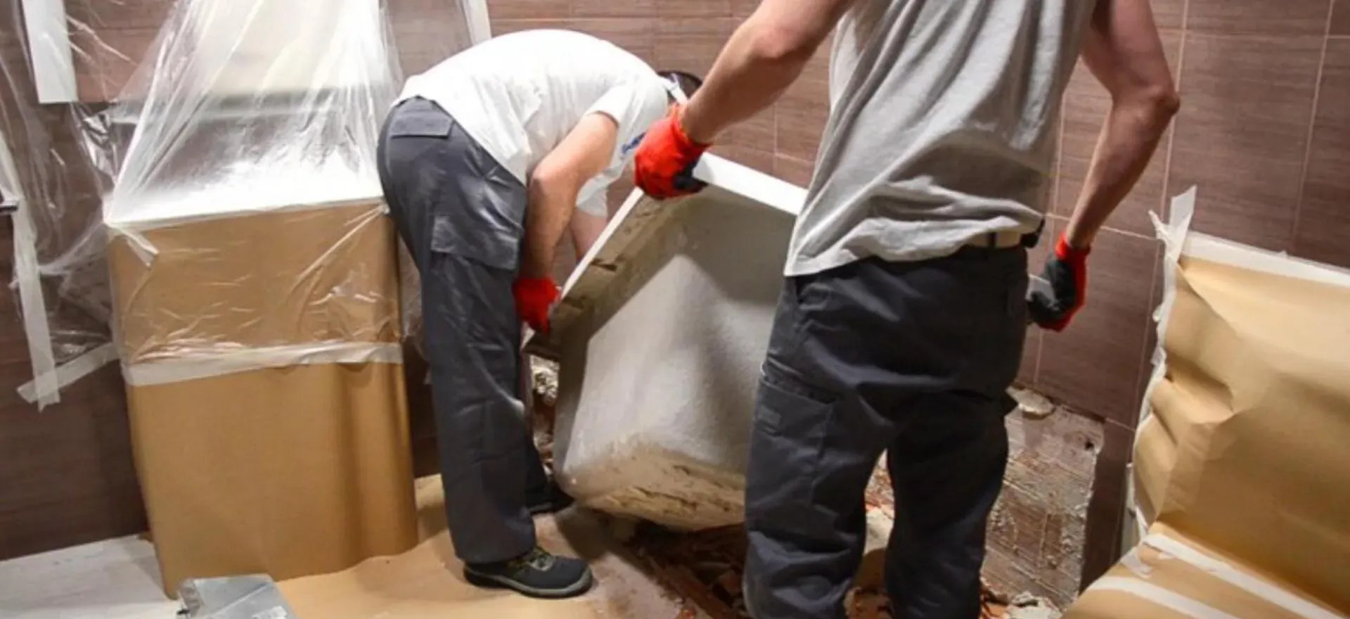 Dos hombres están trabajando en una bañera en un baño.