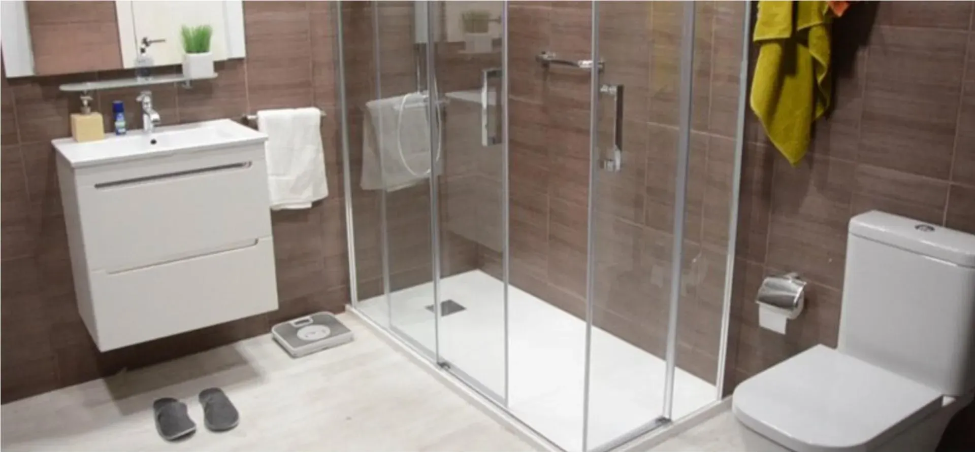 Un baño con inodoro, lavabo y cabina de ducha.
