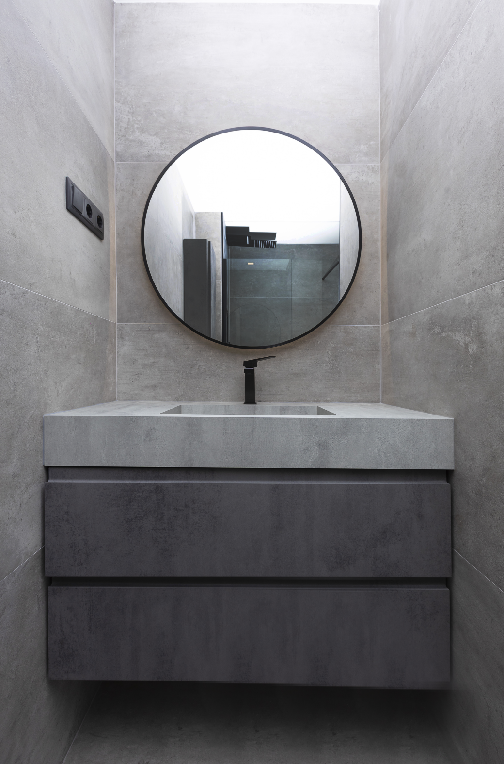 Un baño con lavabo y espejo redondo.