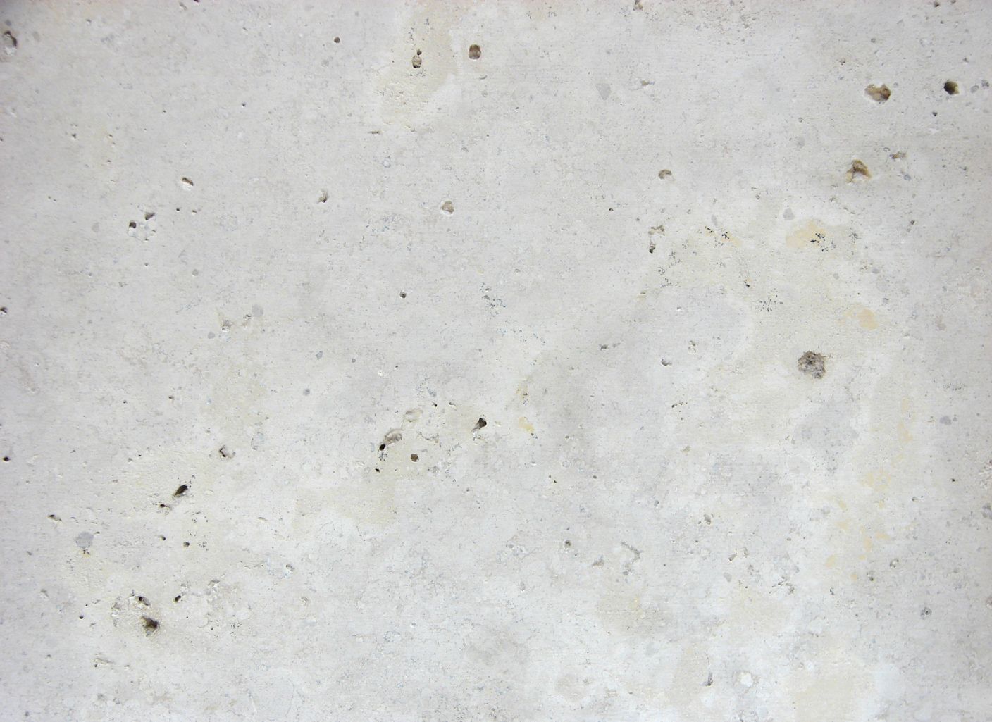Un primer plano de una superficie de hormigón blanco con agujeros.