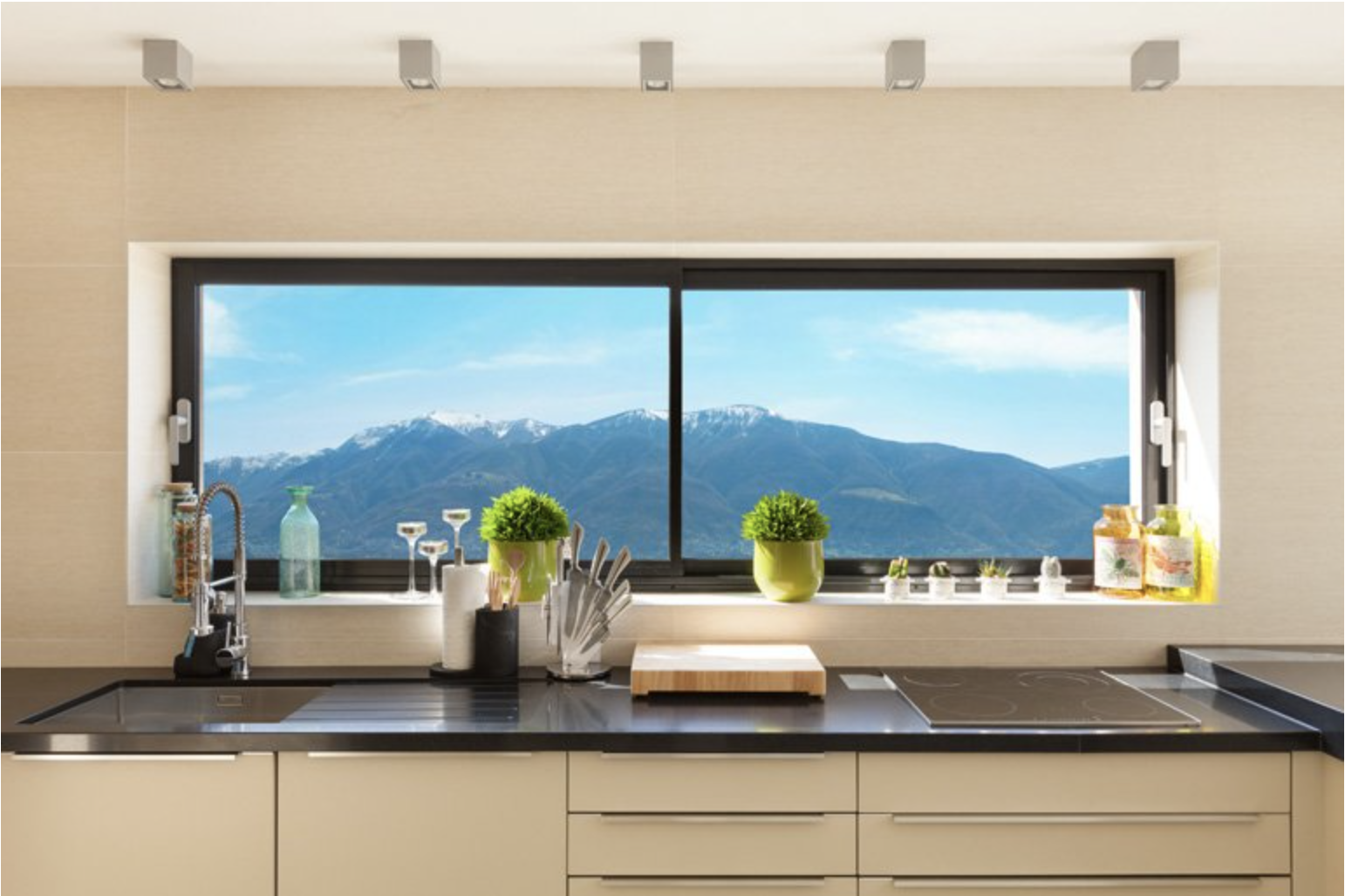 Una cocina con un gran ventanal con vistas a una sierra.