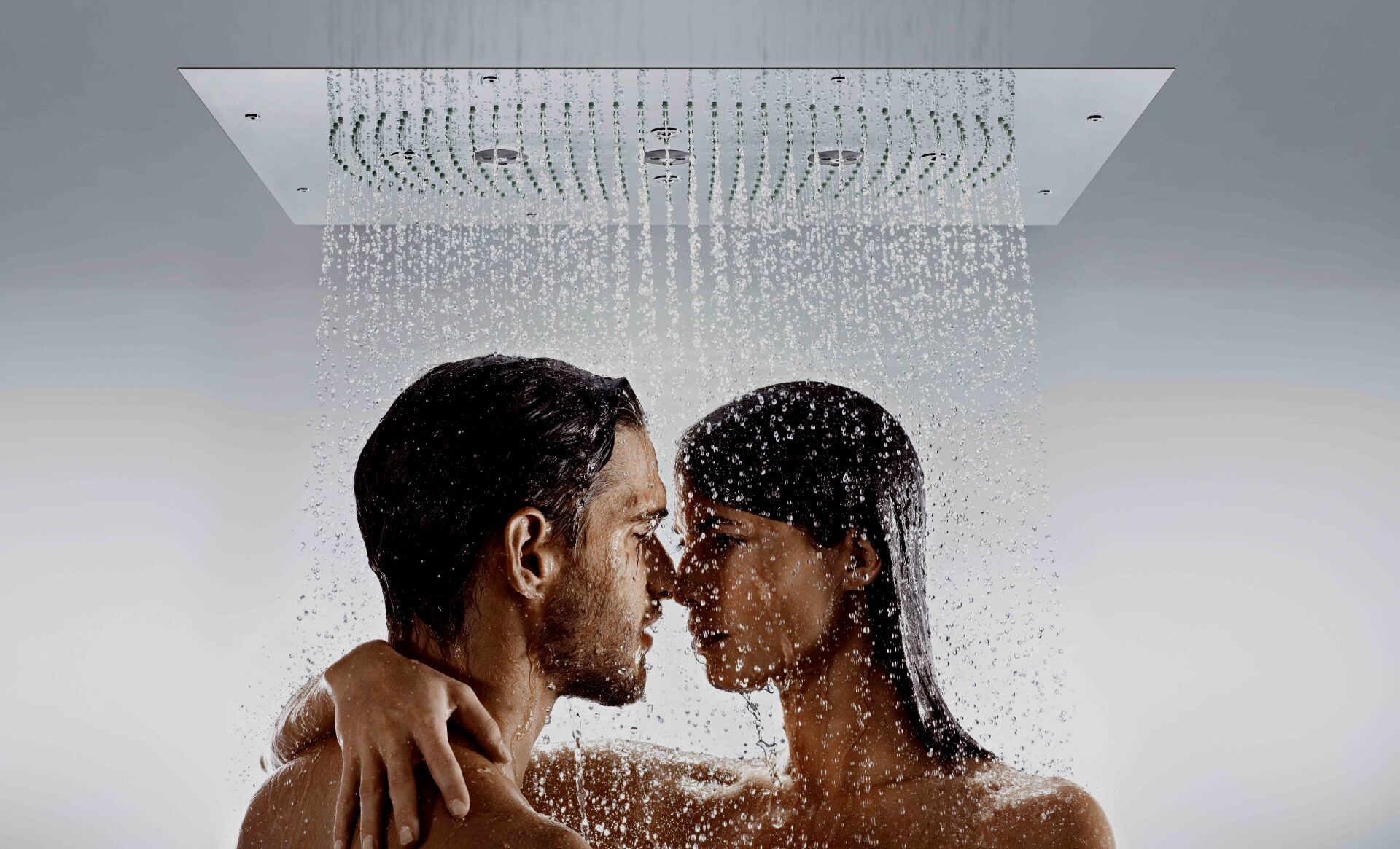 Un hombre y una mujer se besan en la ducha.
