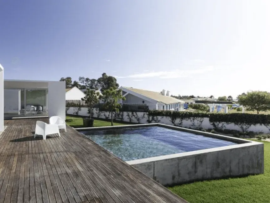 Hay una gran piscina en el patio trasero de una casa.