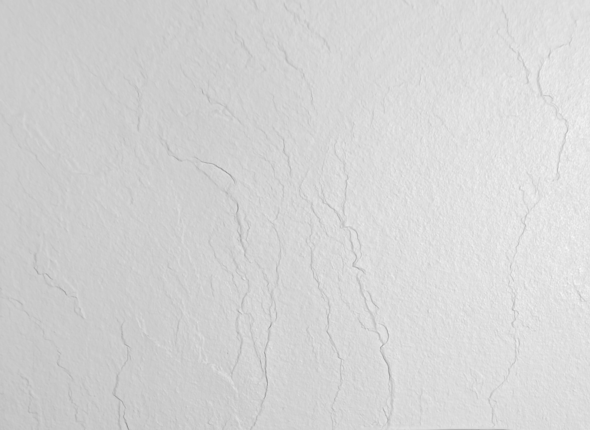 Un primer plano de una pared blanca con grietas.