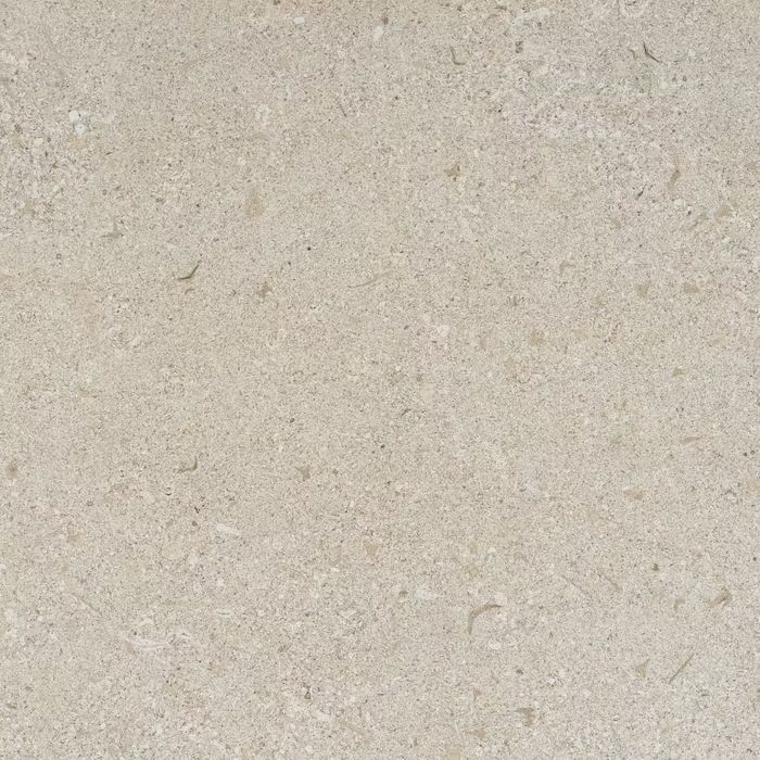 Un primer plano de un azulejo beige con textura granulada.