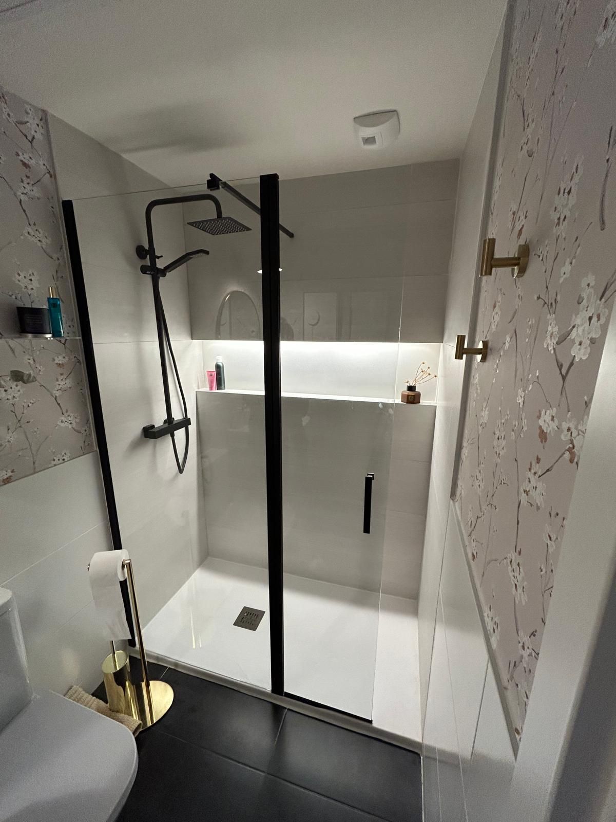 Un cuarto de baño con inodoro, lavabo, espejo y ducha.