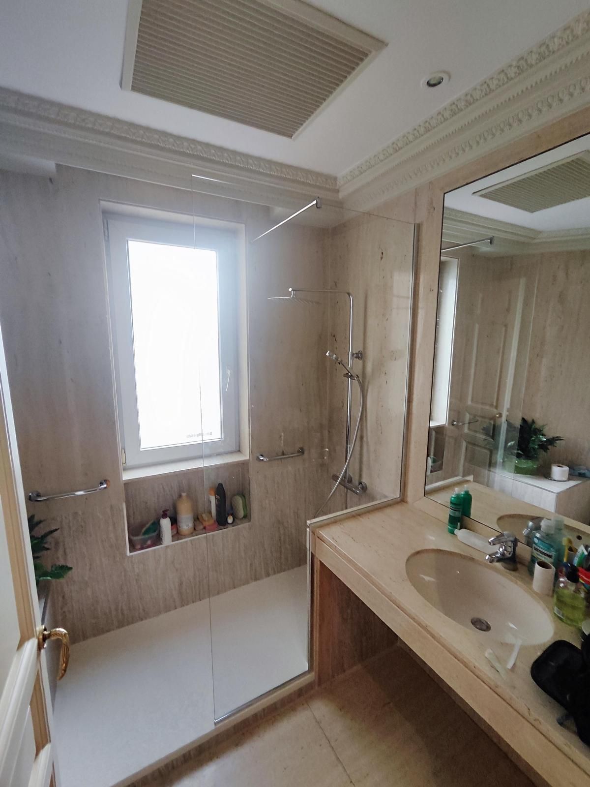 Un cuarto de baño con inodoro, lavabo, espejo y ducha.
