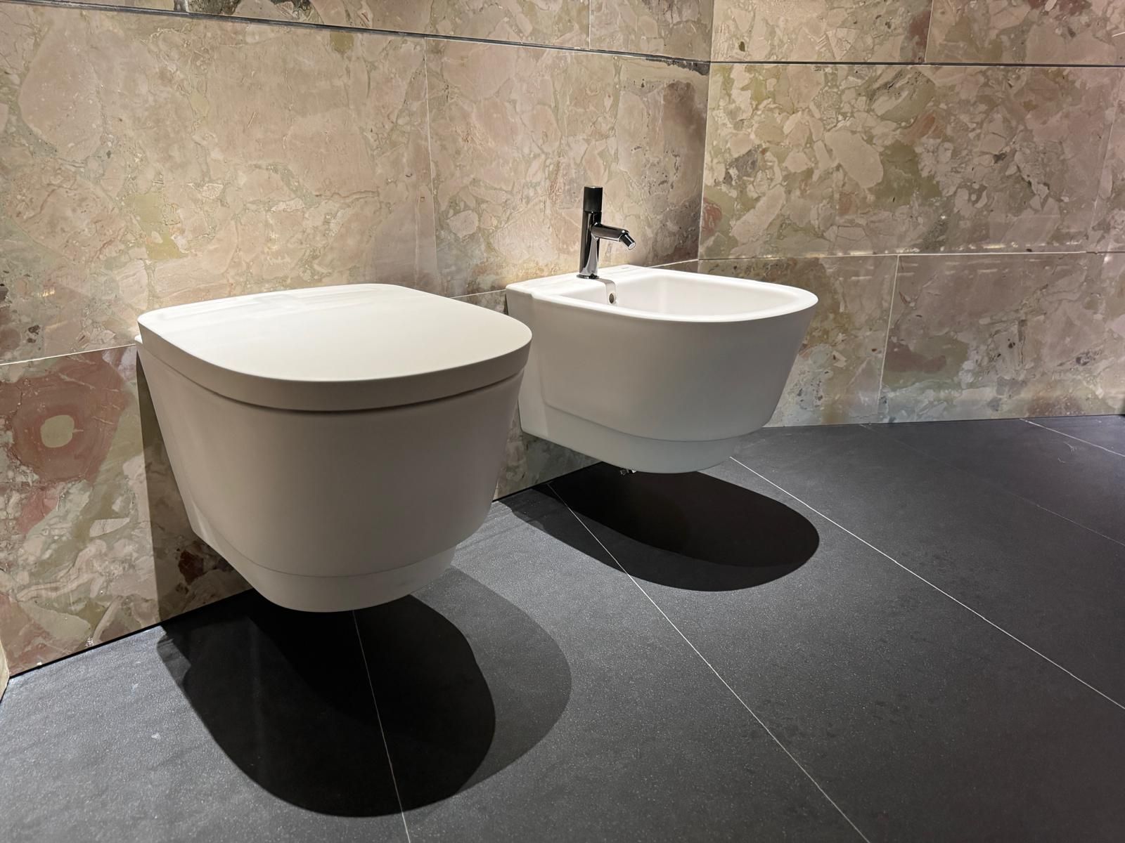 Un cuarto de baño con inodoro, lavabo, espejo y ducha.