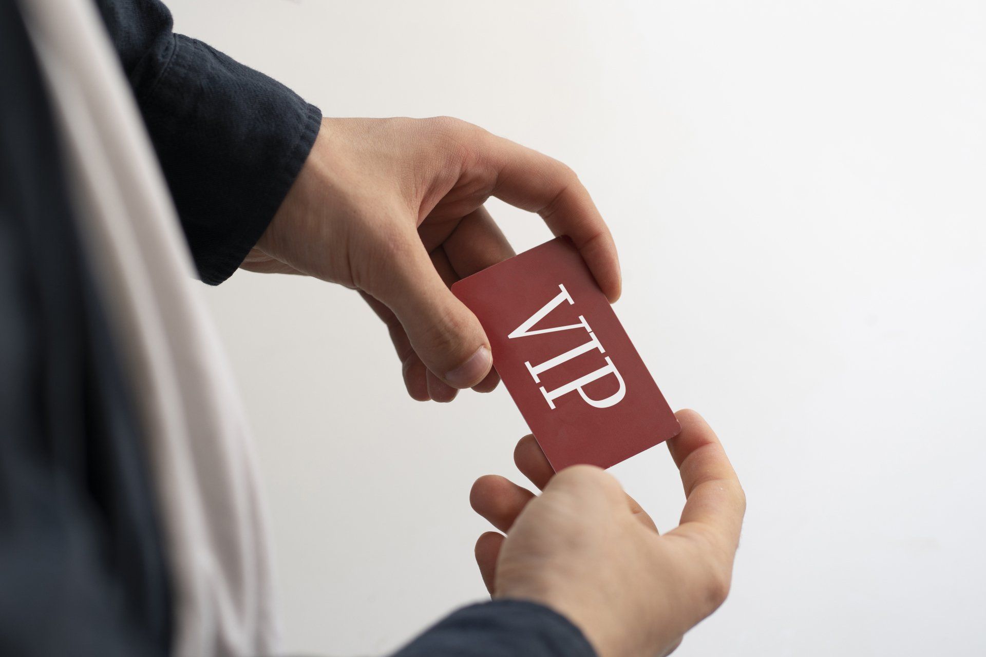 Una persona sostiene una tarjeta roja con la palabra VIP.