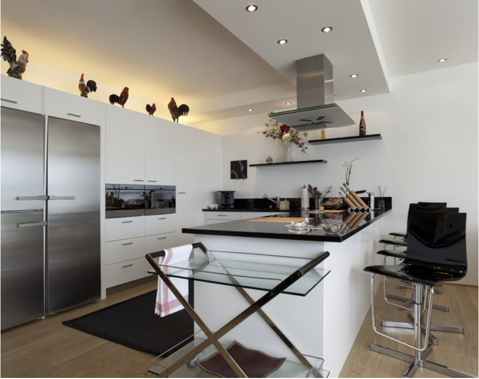 Una cocina con gabinetes blancos y electrodomésticos de acero inoxidable.