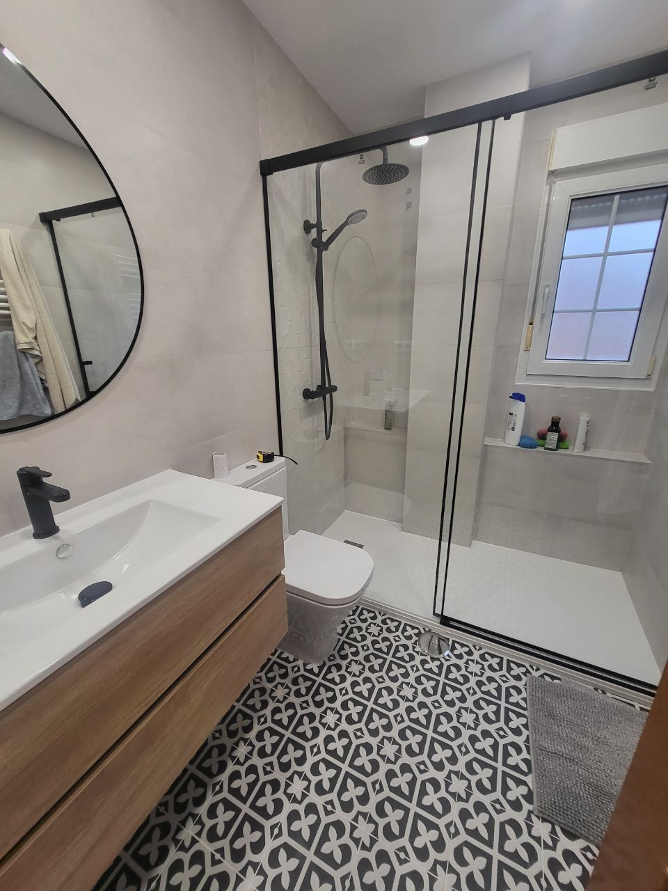 Un cuarto de baño con inodoro, lavabo, espejo y ducha.