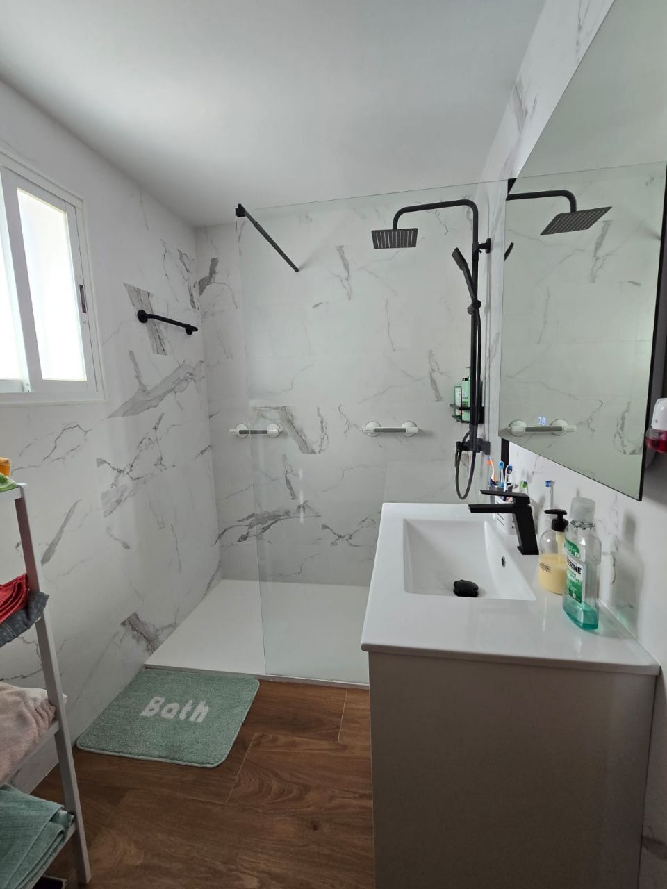 Un cuarto de baño con inodoro, lavabo, espejo y ducha.
