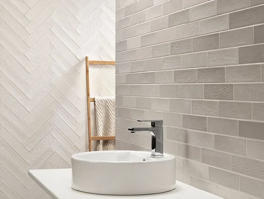 Un baño con lavabo, grifo y toallero.