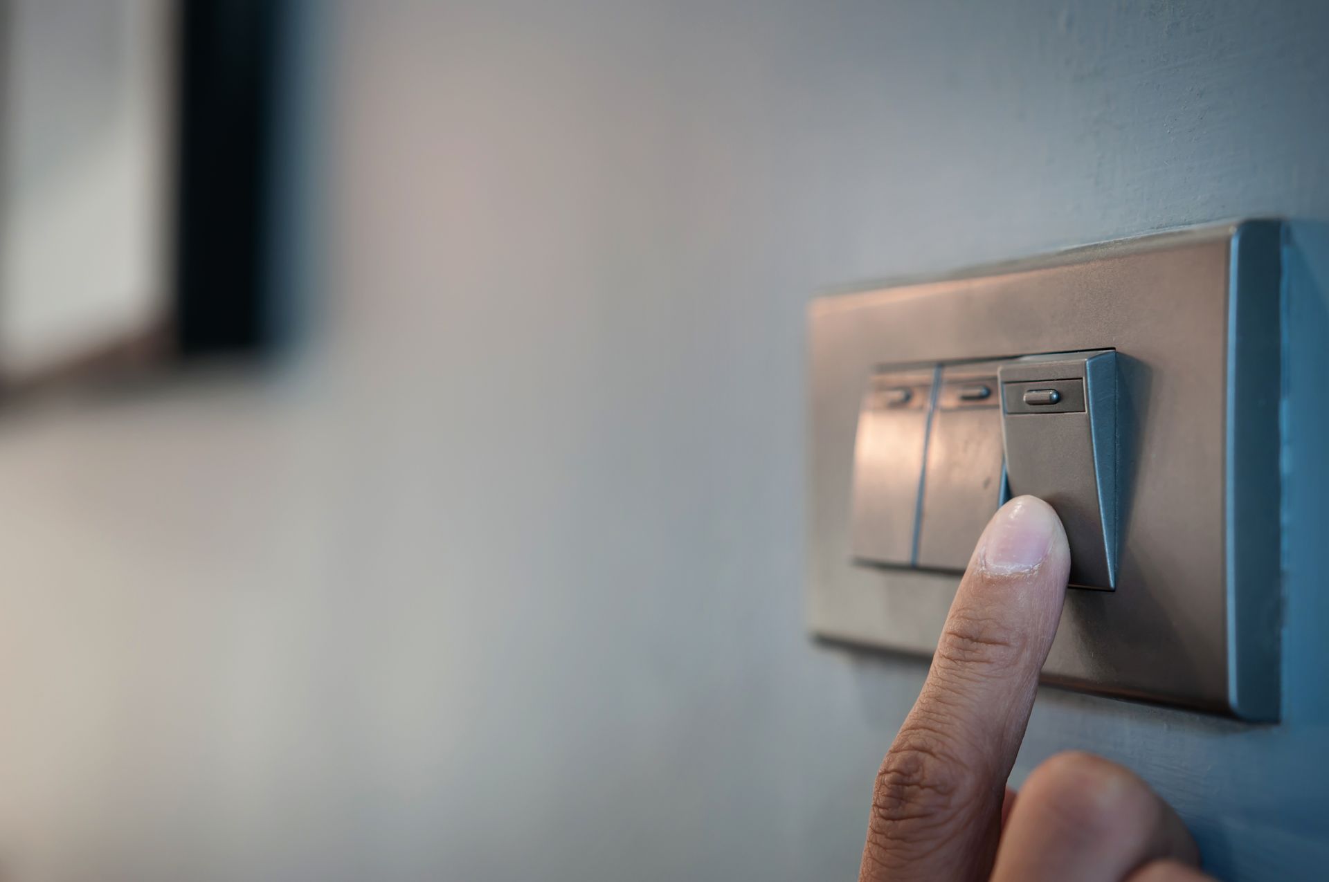 Una persona está presionando un interruptor de luz en una pared.