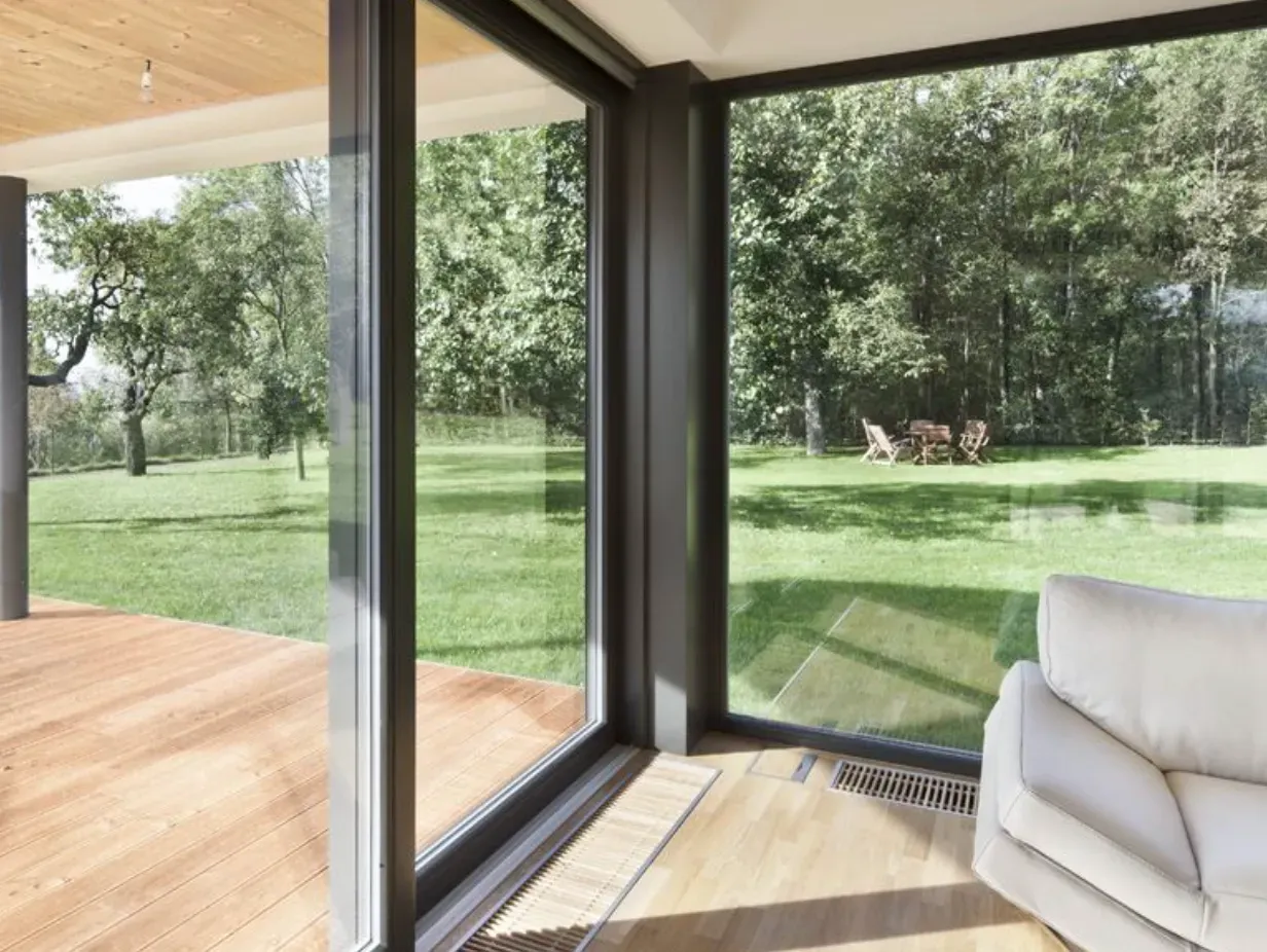 Un salón con sofá y un gran ventanal.