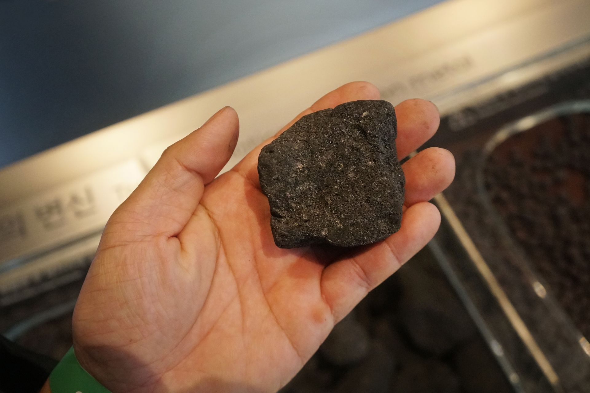 Person wearing gloves holding a section of beige insulation.