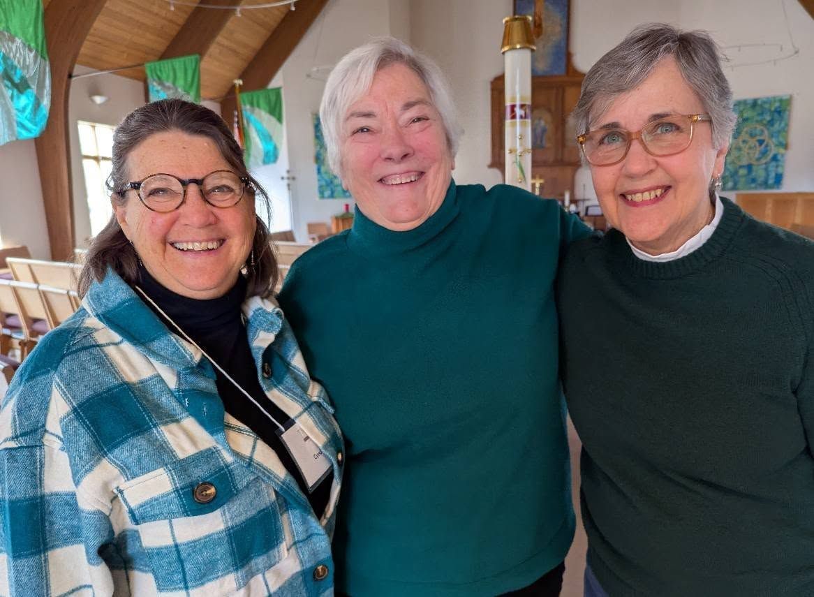 Three women are posing for a picture together in a church