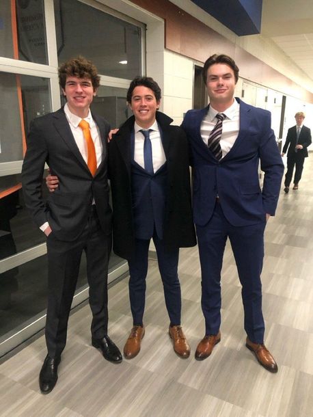 Three men in suits and ties are posing for a picture Three men in suits and ties are posing for a picture