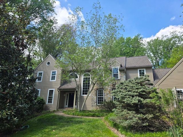 A large house with a lot of windows is surrounded by trees.