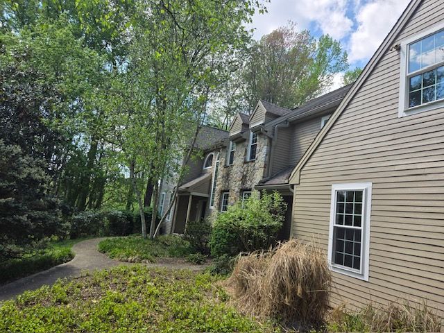 A large house with a lot of windows is surrounded by trees and bushes.