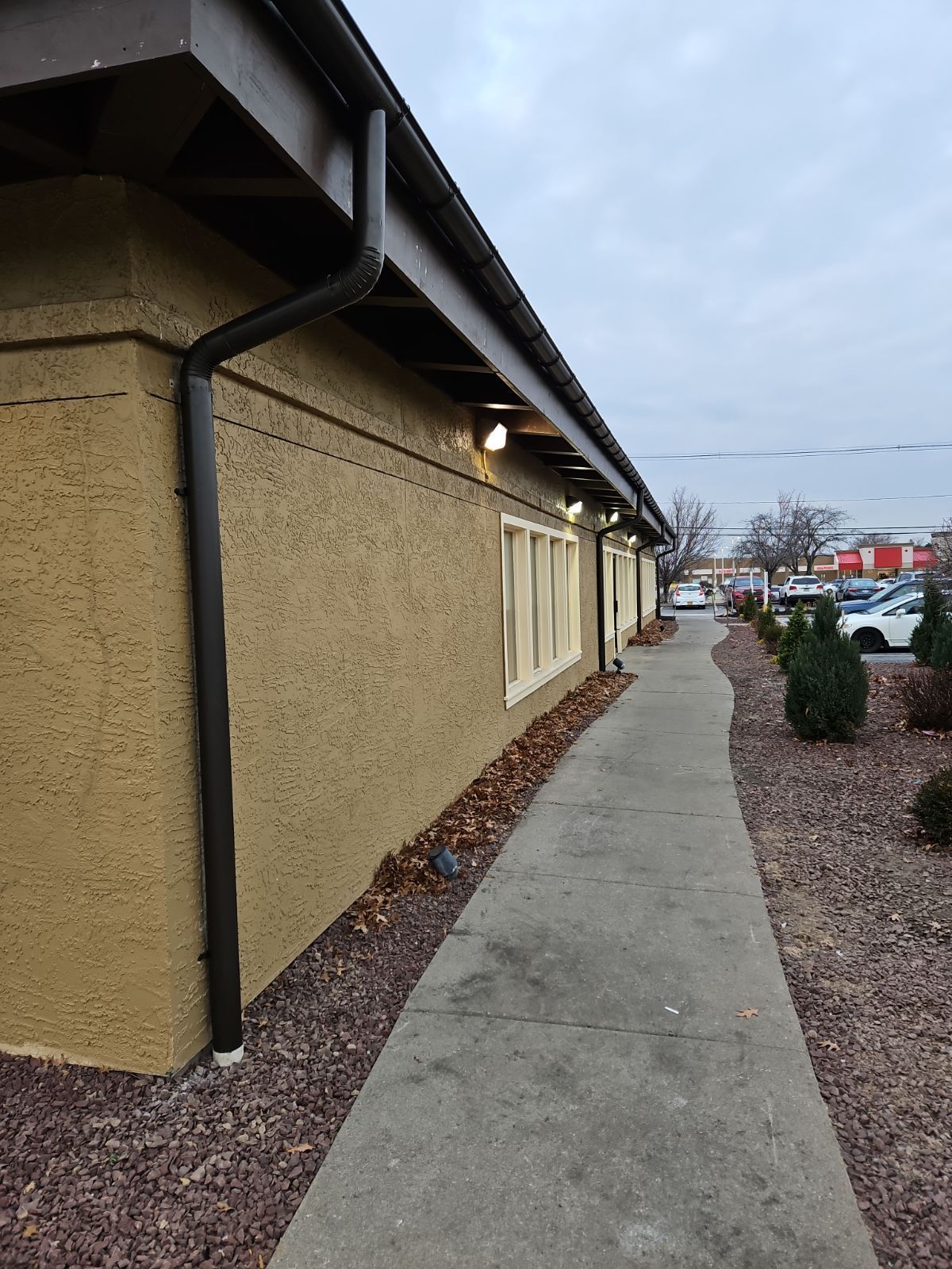 A Sidewalk Leading to a Building with a Black Gutter – Lititz, PA – Trailside Spouting, LLC