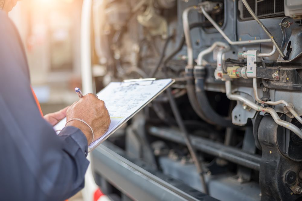 A Man Is Writing On A Clipboard In Front Of A Train Engine — Jasco Automotive In Bowen, QLD