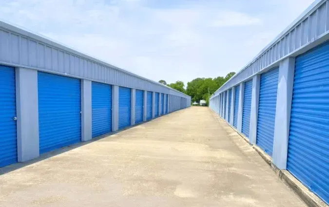 Rows of blue storage units with a concrete walkway.