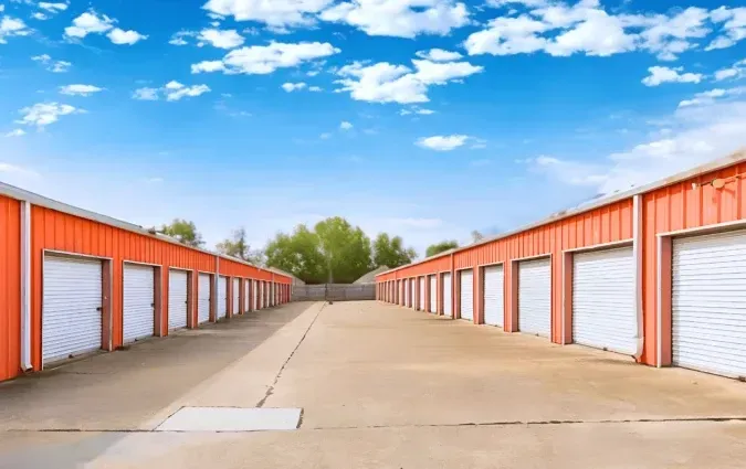 Rows of orange storage units with white doors under a blue sky.